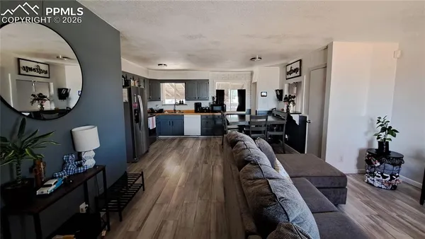 a view of a livingroom with furniture hardwood floor and a kitchen