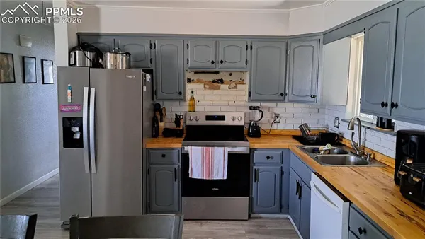 a kitchen with stainless steel appliances granite countertop a refrigerator a stove and a sink