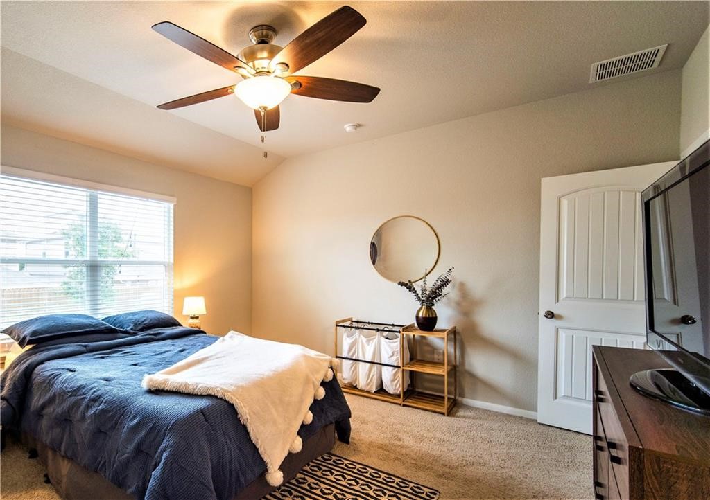 10406 Hatton Lane Austin, TX 78754 - Photo 12 of 22 a bedroom with a bed and a chandelier