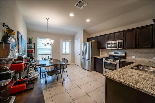 a kitchen with granite countertop a sink appliances and cabinets