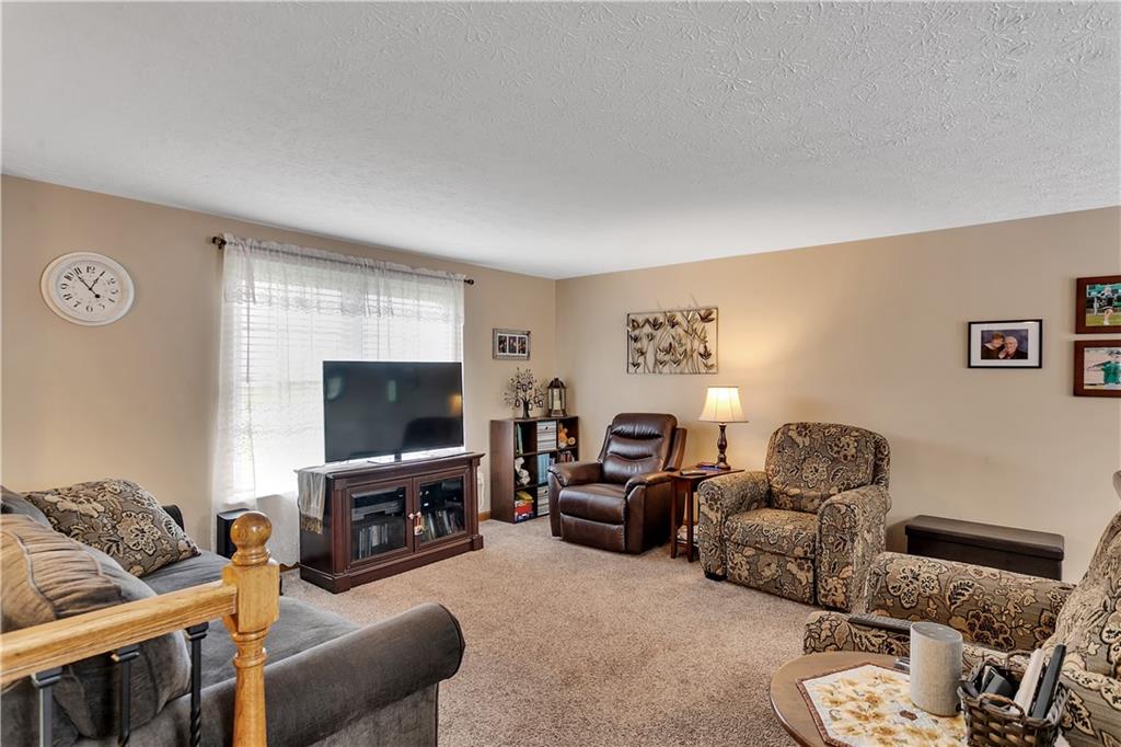 227 Brewer Road Freedom, PA 15042 - Photo 7 of 34 a living room with furniture a flat screen tv and a fireplace