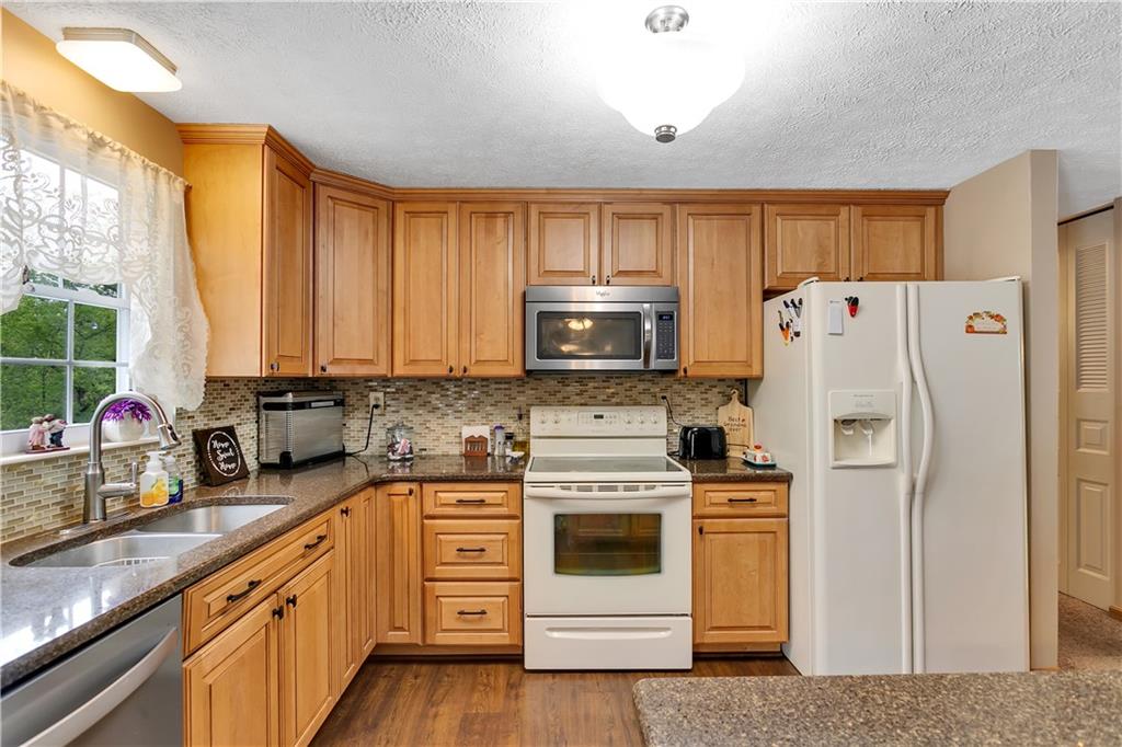 227 Brewer Road Freedom, PA 15042 - Photo 8 of 34 a kitchen with granite countertop white cabinets and white appliances