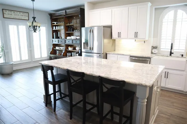 a kitchen with granite countertop cabinets stainless steel appliances and wooden floor