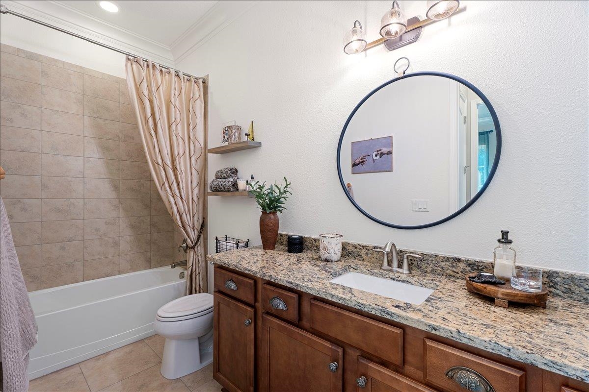 145 Paranza Trace St. Augustine, FL 32095 - Photo 17 of 34 a bathroom with a granite countertop sink mirror vanity and toilet