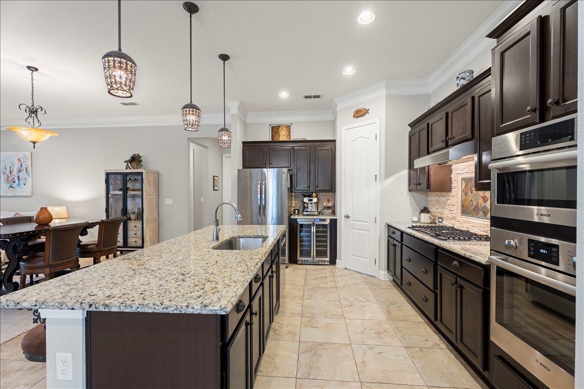 145 Paranza Trace St. Augustine, FL 32095 - Photo 8 of 34 a large kitchen with stainless steel appliances kitchen island granite countertop a large kitchen island and a refrigerator