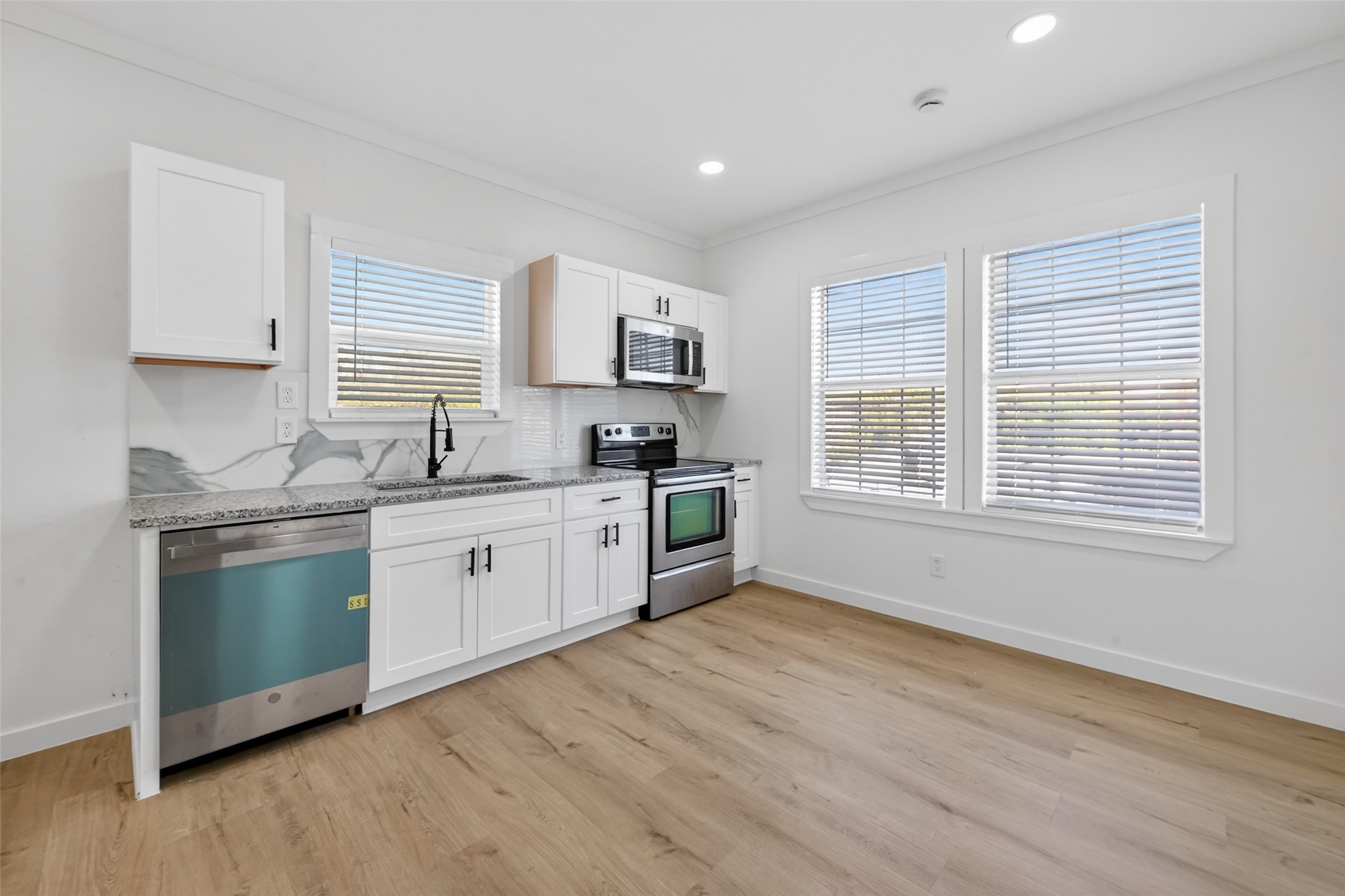2202 Hutchins Street, Unit D Houston, TX 77003 - Photo 11 of 33 a kitchen with granite countertop white cabinets and white appliances