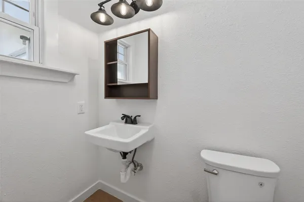 a bathroom with a toilet sink and mirror