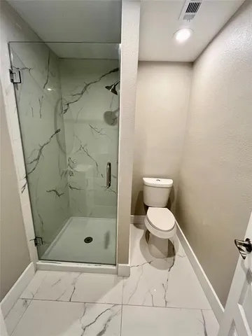 a bathroom with a toilet and a shower