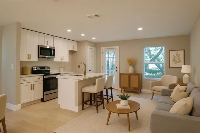 a living room with furniture kitchen view and a window