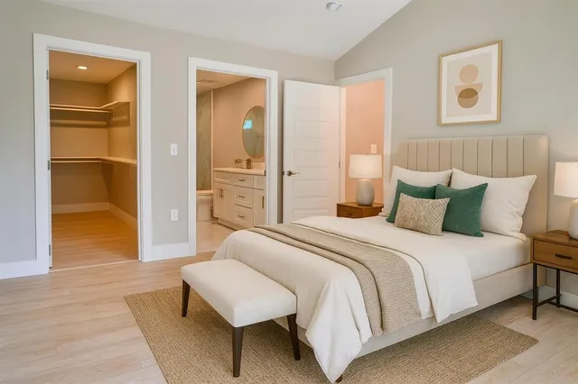 a spacious bedroom with a bed and wooden floor