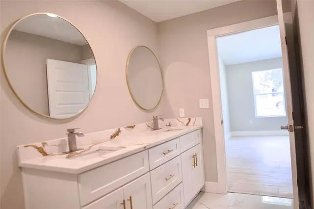 a bathroom with a double vanity sink and a mirror