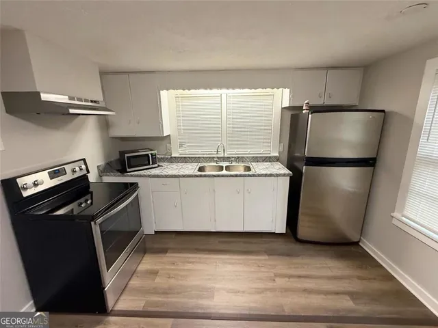 a kitchen with a refrigerator a stove a microwave and cabinets