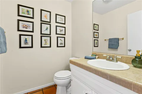 a bathroom with a granite countertop sink mirror and toilet