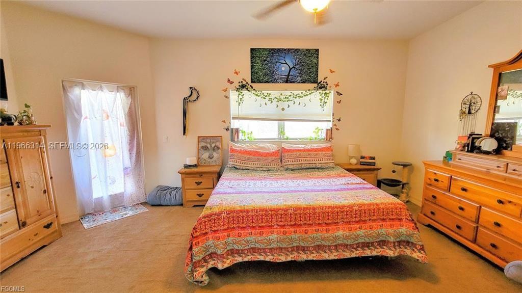 4529 Springview Circle LaBelle, FL 33935 - Photo 6 of 11 a bedroom with a bed and a flat tv screen on dresser