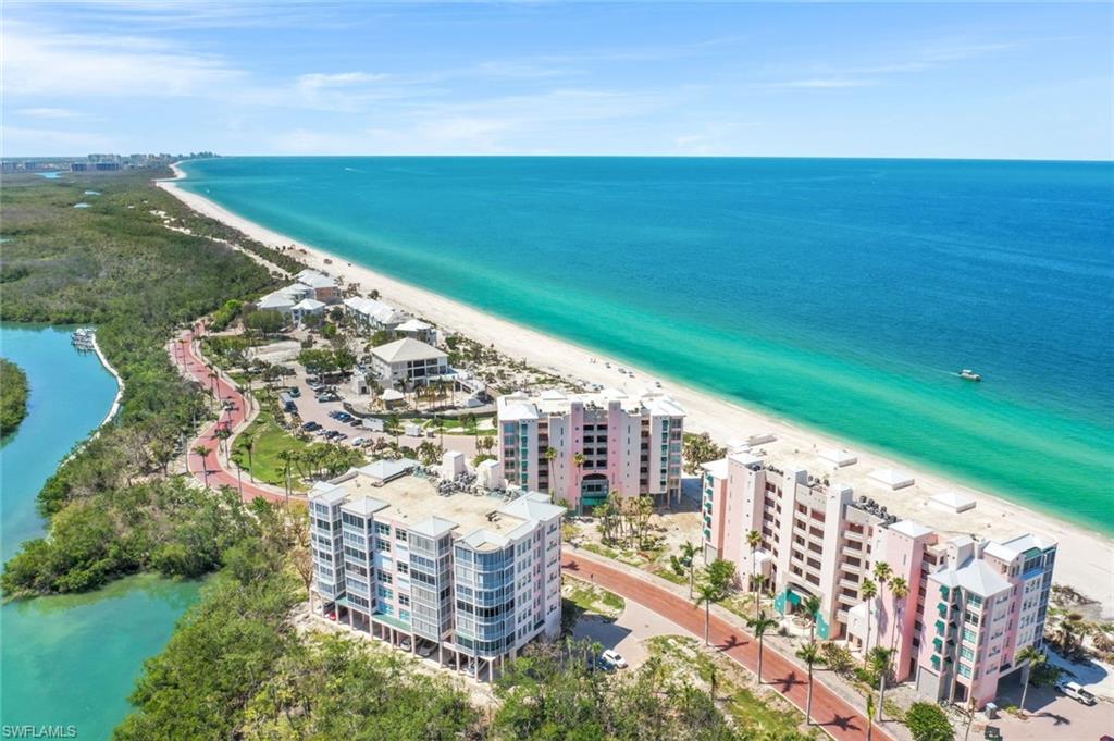 269 Barefoot Beach Boulevard, Unit 403 Bonita Springs, FL 34134 - Photo 1 of 27 Drone / aerial view of apartment complex / building and waterfront with a beach