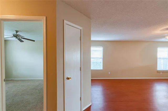 a view of a room with wooden floor closet and windows