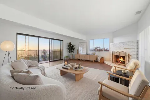 a living room with furniture a fireplace and a floor to ceiling window