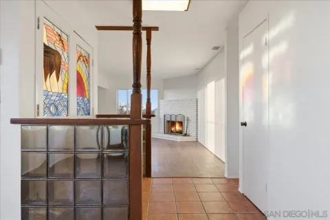 a view of an empty room with a window and fireplace