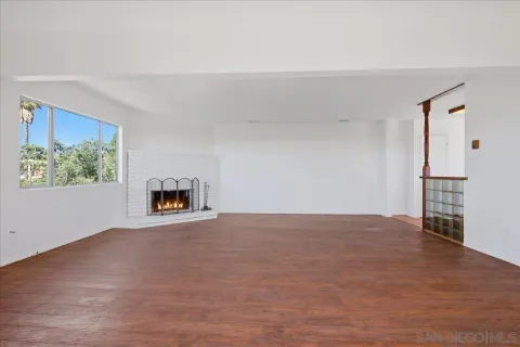a view of an empty room with a fireplace and a window
