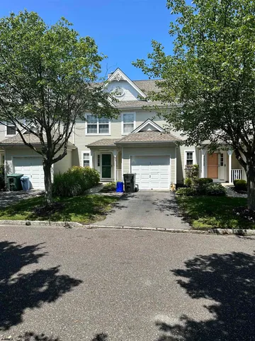 a front view of a house with a yard and a garage
