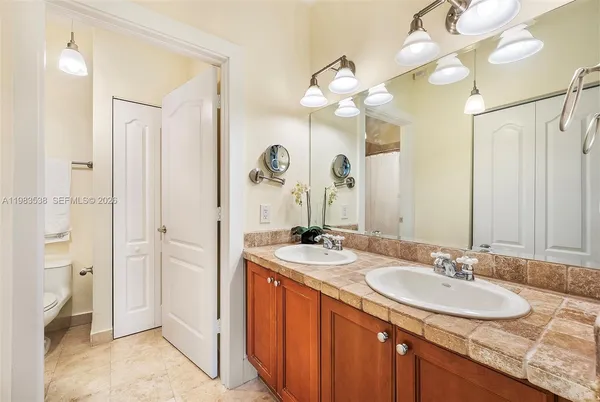a bathroom with a granite countertop sink and a mirror
