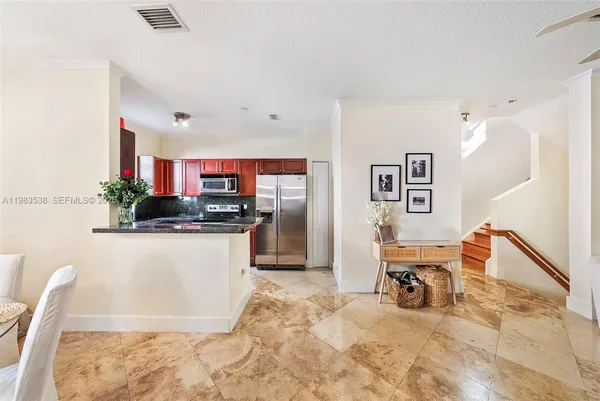 a kitchen with stainless steel appliances kitchen island granite countertop a refrigerator and a sink