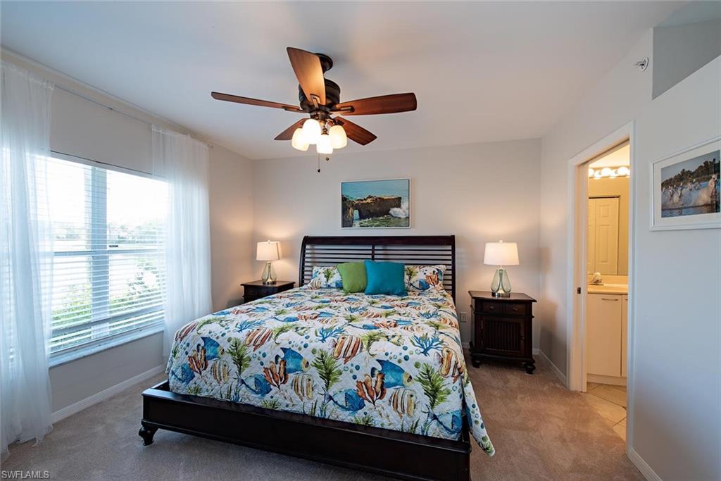 4960 Deerfield Way, Unit E103 Naples, FL 34110 - Photo 12 of 14 a bedroom with a bed and a window