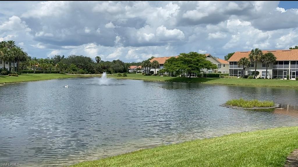 4960 Deerfield Way, Unit E103 Naples, FL 34110 - Photo 13 of 14 a view of a lake with houses in the background