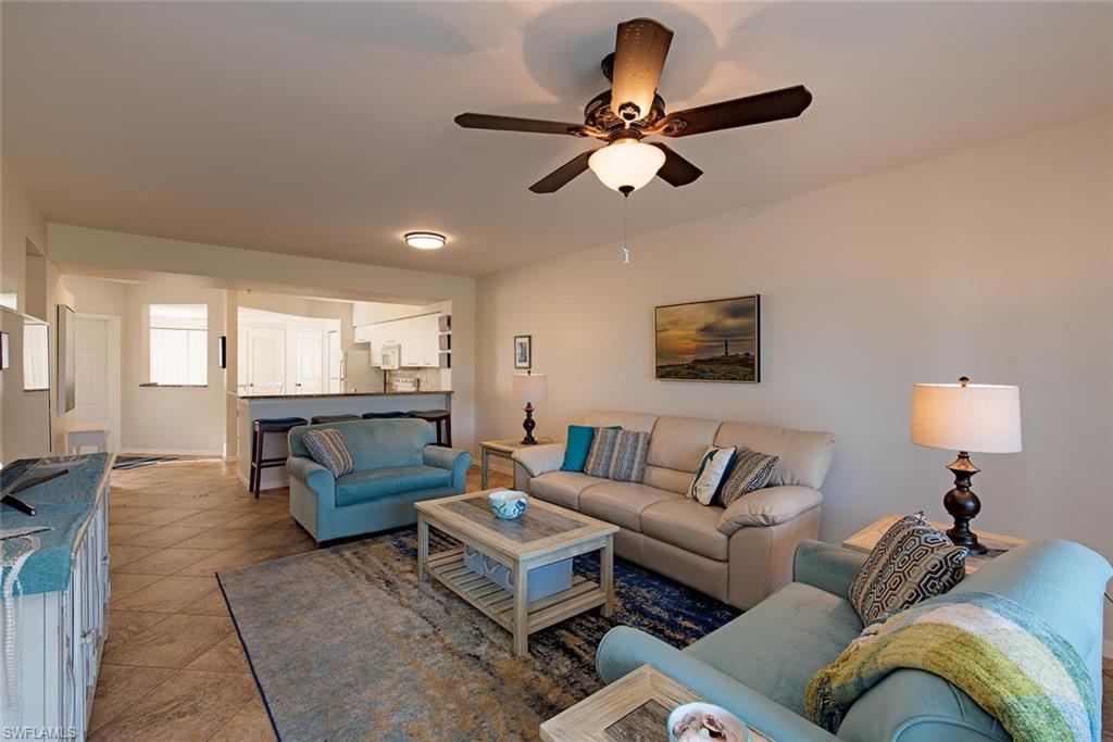 4960 Deerfield Way, Unit E103 Naples, FL 34110 - Photo 5 of 14 a living room with furniture and a large window