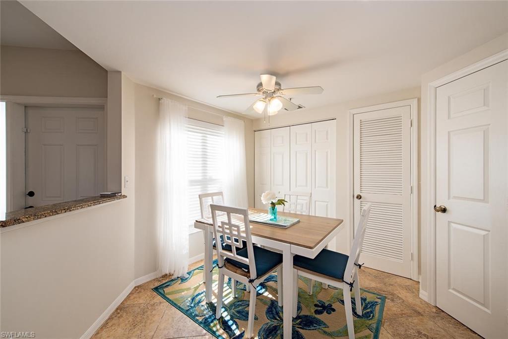 4960 Deerfield Way, Unit E103 Naples, FL 34110 - Photo 8 of 14 a view of a dining room with furniture and a chandelier