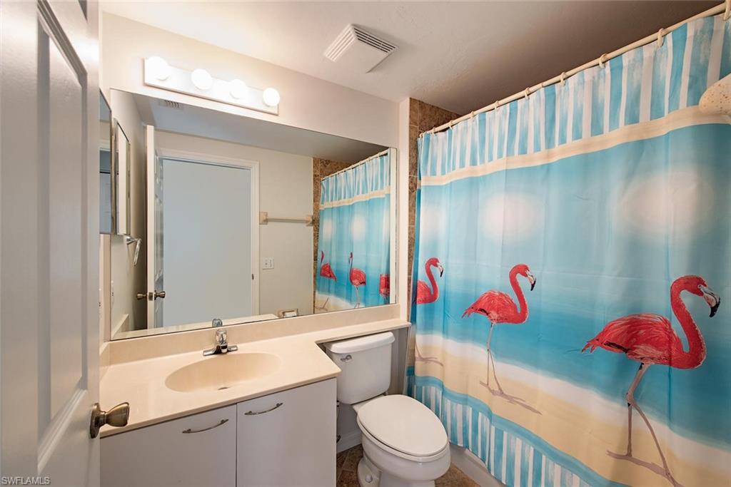 4960 Deerfield Way, Unit E103 Naples, FL 34110 - Photo 10 of 14 a bathroom with a sink mirror vanity and toilet