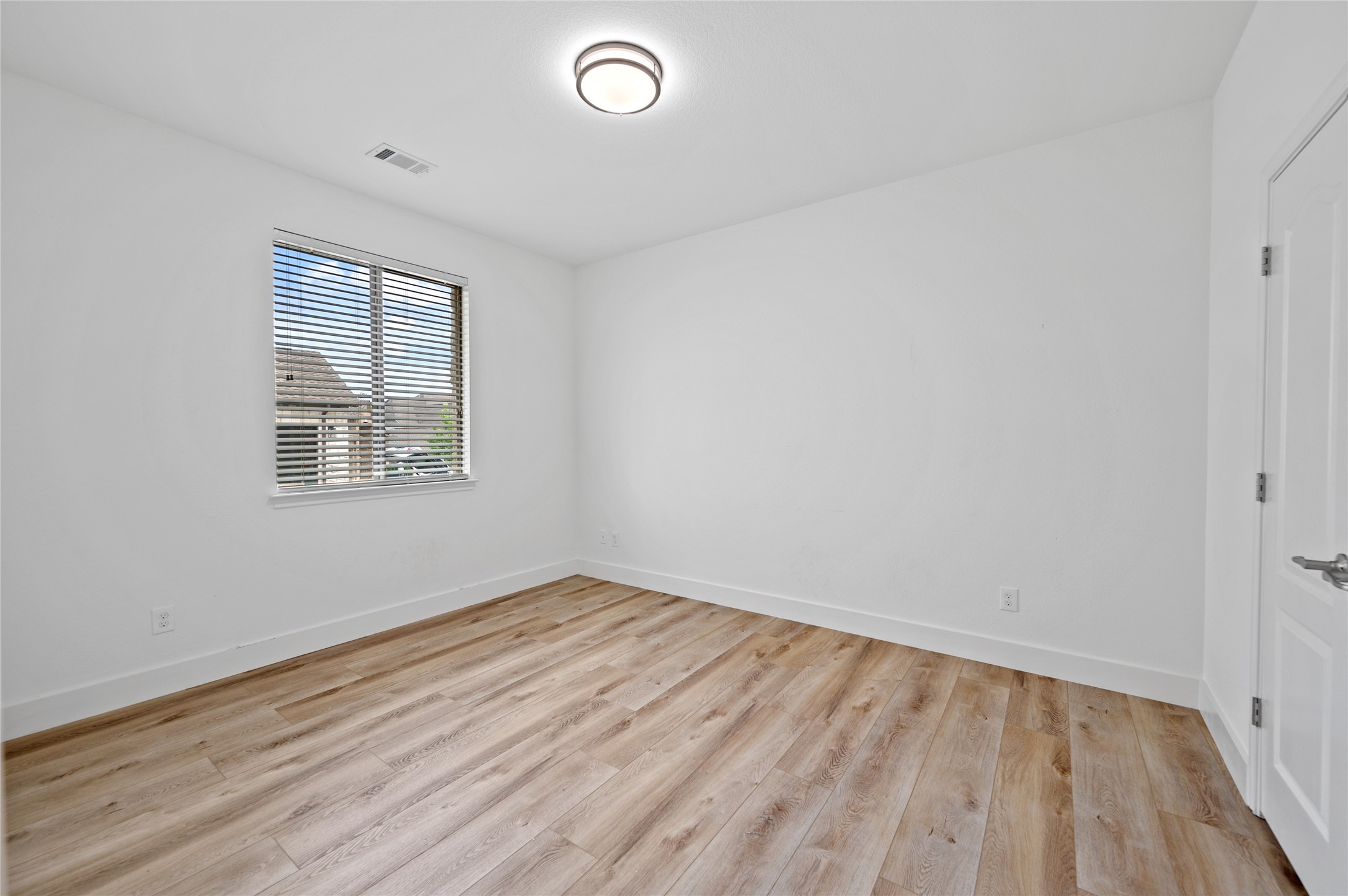 4512 Pyrenees Pass Bee Cave, TX 78738 - Photo 23 of 35 an empty room with wooden floor and windows