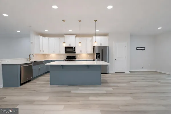 a large kitchen with kitchen island a sink stainless steel appliances and cabinets
