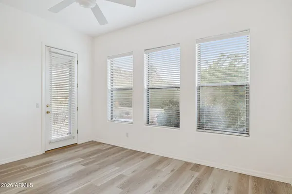 an empty room with a window and a ceiling fan