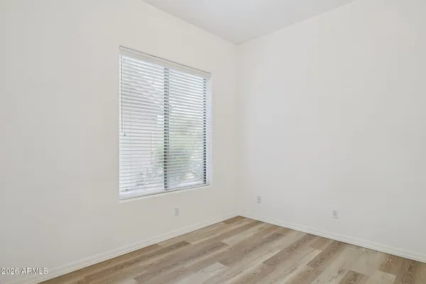 a view of an empty room with closet and a window