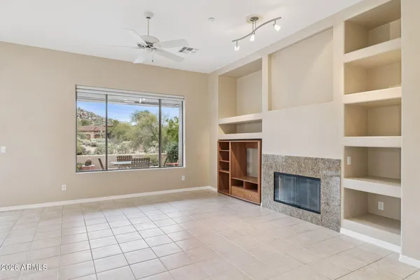 an empty room with a fireplace cabinet and a window