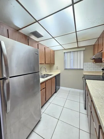 a kitchen with stainless steel appliances granite countertop a refrigerator a sink and a stove