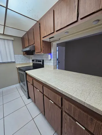 a kitchen with stainless steel appliances granite countertop a sink a stove and cabinets