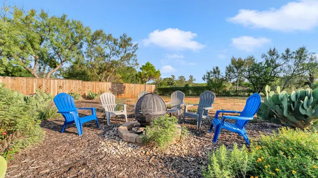 a view of a backyard with plants and chairs