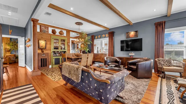 a living room with furniture a flat screen tv and a floor to ceiling window