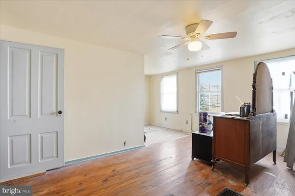 a view of a livingroom with wooden floor and a ceiling fan