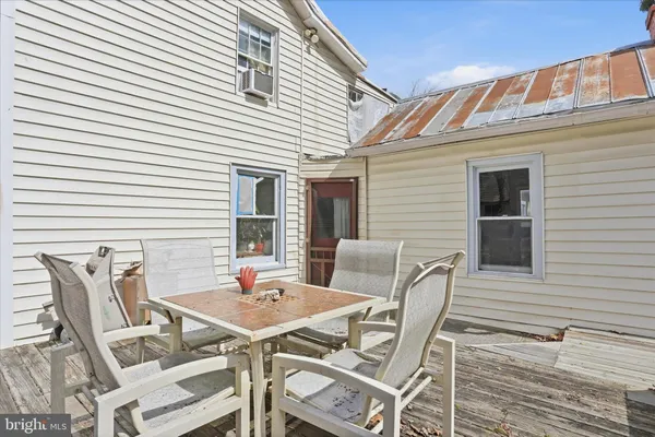 a patio with table and chairs and potted plants
