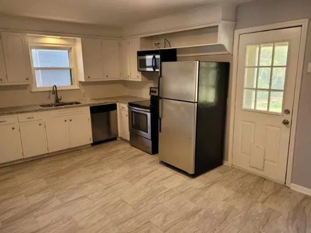 a kitchen with stainless steel appliances a refrigerator sink and cabinets