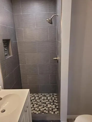a bathroom with a sink a toilet and shower