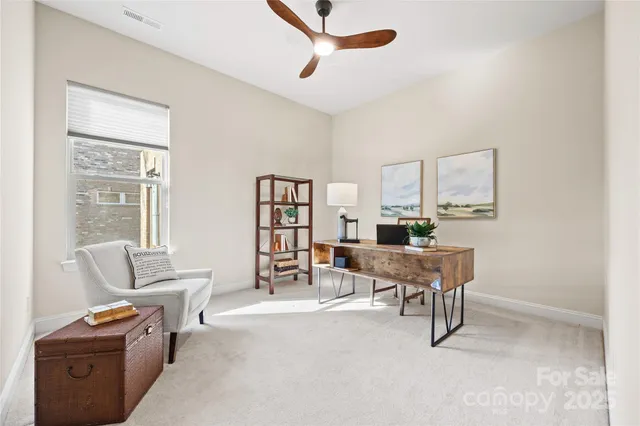 a work room with furniture a air conditioner vent and a window
