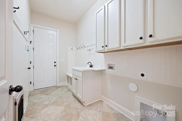 a view of cabinets and utility room with closet