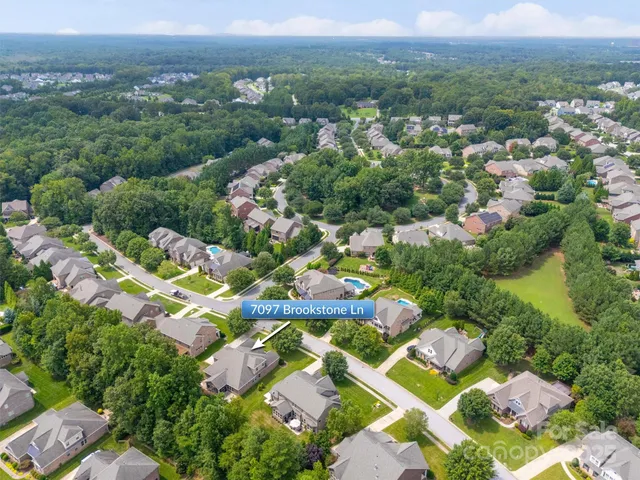 an aerial view of residential houses with outdoor space and parking