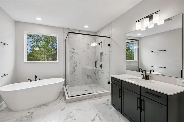 a spacious bathroom with a bathtub sink mirror and toilet