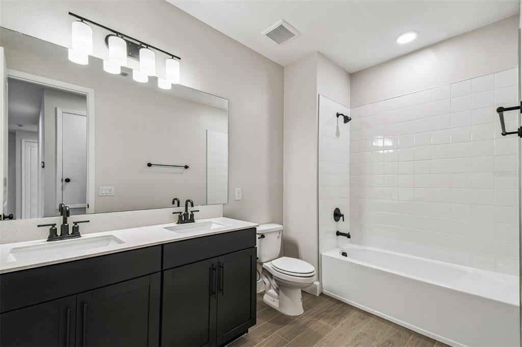 5262 Prairie Preserve Run St. Cloud, FL 34772 - Photo 28 of 40 a bathroom with a sink a toilet and shower