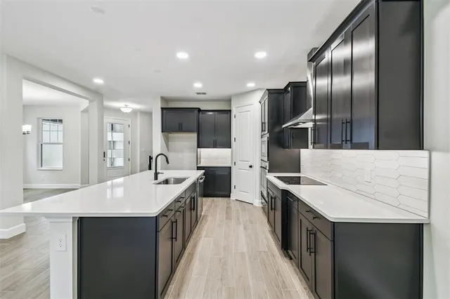 a large kitchen with kitchen island a sink stove and refrigerator